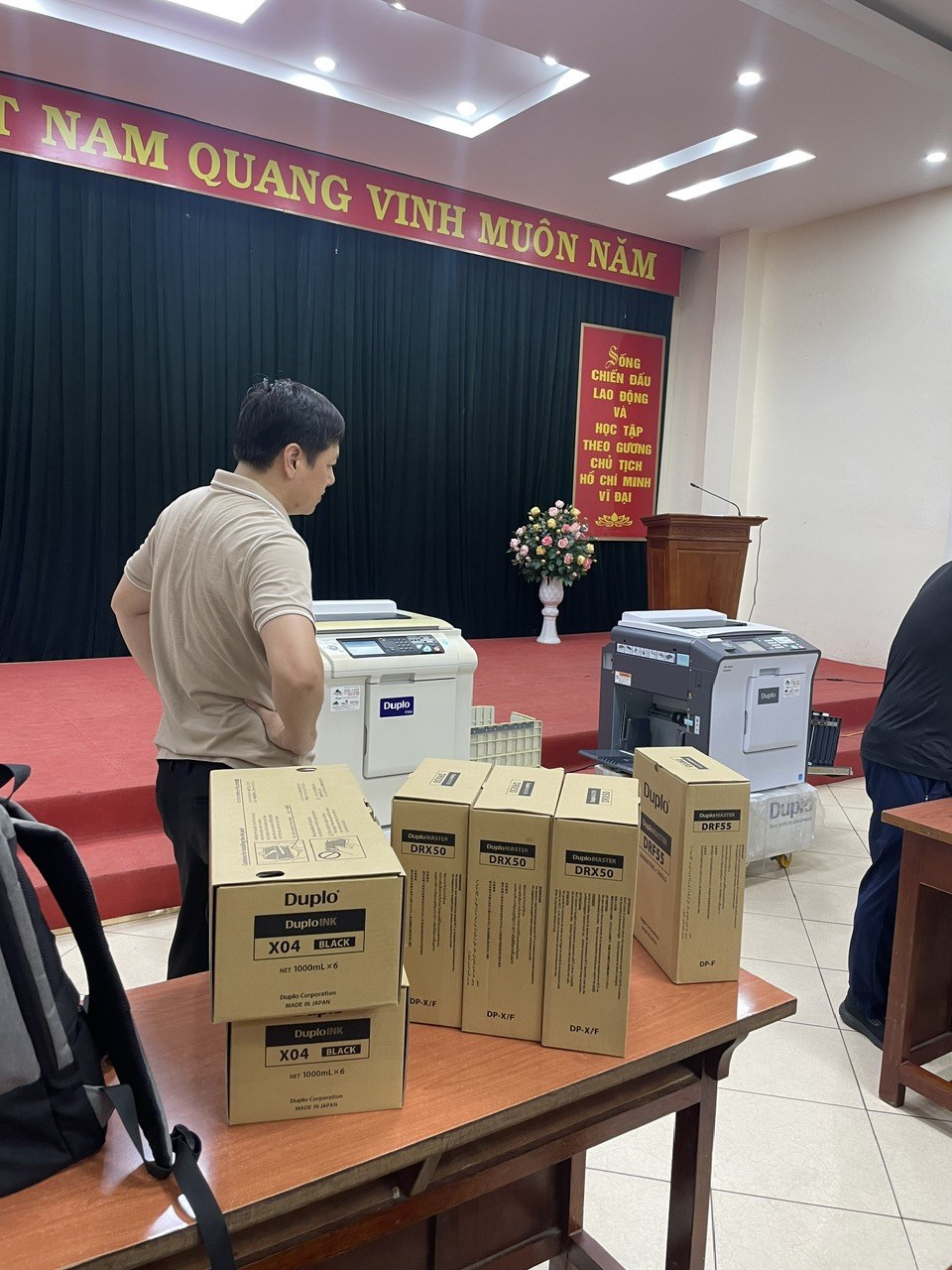 Bàn giao máy in siêu tốc Duplo trong khu vực in sao đề thi cách ly